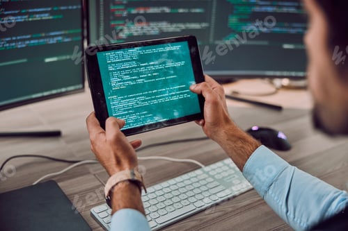 Preview: Coding, computer and tablet in hands with man, programmer and software update, IT and code at desk.