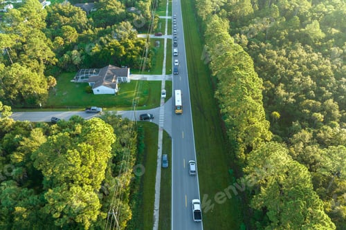 Preview: Top view of standard american yellow school bus picking up kids at rural town street stop