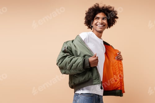 Preview: Portrait of handsome authentic young man with piercing in nose wearing stylish green jacket