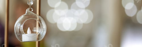 Preview: Banner a glass vase with a candle inside of it. Wed decore