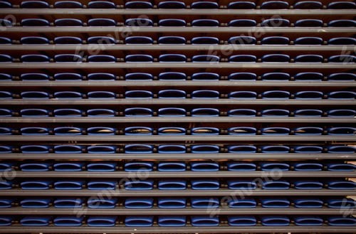Preview: A row of folded seats on shelves in an indoor sports venue.