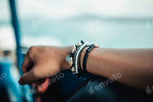 Preview: Hands and nautical bracelets placed on the chairs of a sailing ship.