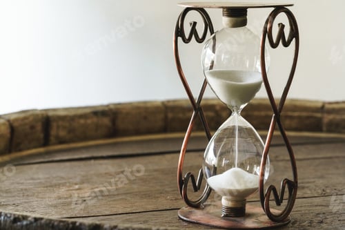 Preview: Sandglass on wooden bakground closeup. Time concept
