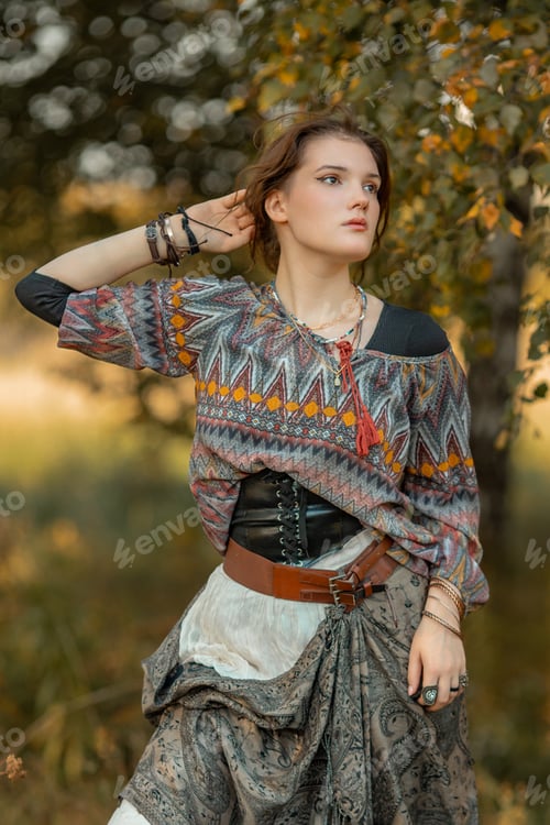 Preview: Young woman in boho style clothes posing in autumn forest