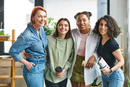 Preview: cheerful multicultural female friends in stylish casual clothes, with smartphone, paper cup