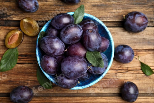 Preview: Delicious ripe plums on wooden table, flat lay