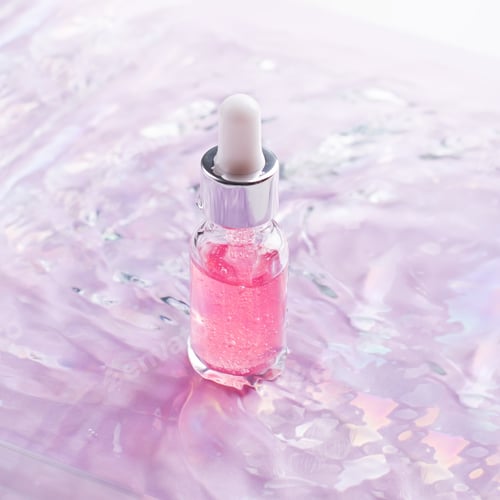 Preview: Bottle of hyaluronic serum with rose oil in water, closeup
