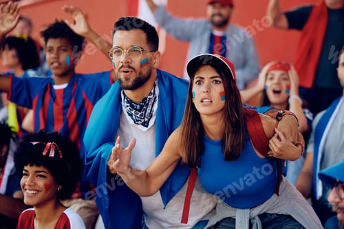 Preview: Young couple cheering for their team during a sports match on a stadium.