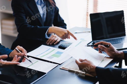 Preview: Close up view of business people discussing the charts and graphs showing the results of their succ