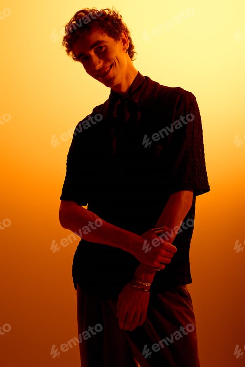 Preview: Striking young man showcases modern fashion against warm sunset backdrop