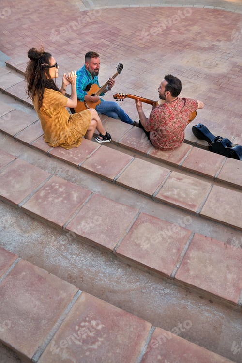 Preview: Musicians performing flamenco music outdoors, two guitarists playing and a woman clapping hands