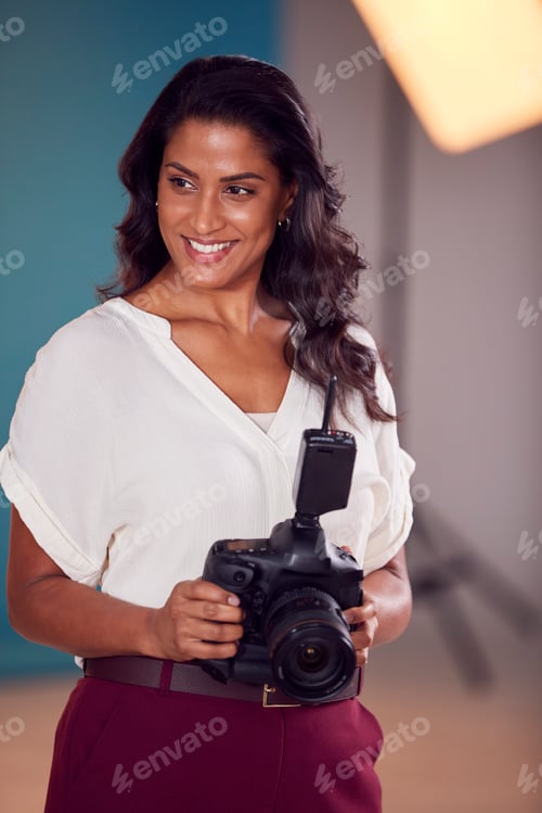 Preview: Mature Female Photographer With Camera In Studio For Shoot