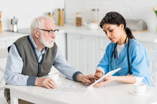 Senior Man with Caregiver Looking at Tablet