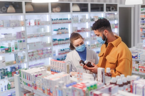 Preview: Young pharmacist helping customer to choos medication.