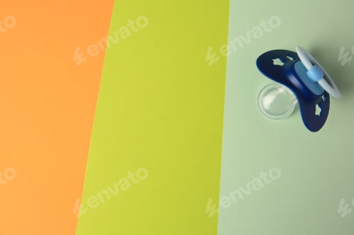Preview: Baby pacifier on color background, top view. Space for text