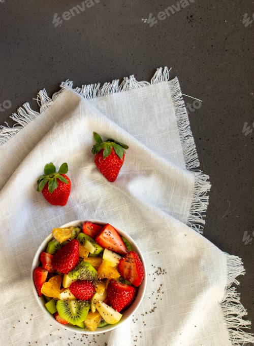 Preview: Bowl of healthy fresh fruit salad on white background. Top view