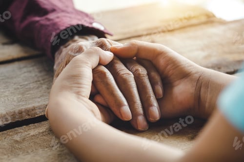 Preview: Hands of the old man and a child's hand on the wood table