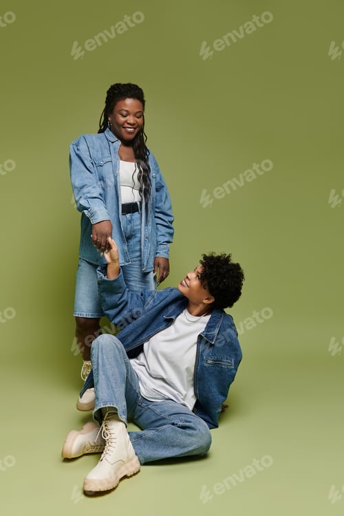 Preview: Stylish lesbian couple shares a joyful moment in vibrant outfits against a bright backdrop