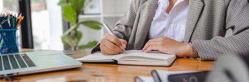 Preview: Close up of businesswomen writting notebook and working online via laptop computer for analytic busi