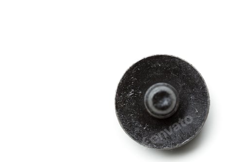 Preview: Close-up view of a black metal fastener resting on a white surface with shadows