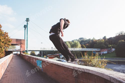 Preview: Young sportive athletic man doing parkour outdoors city jumping beyond obstacle