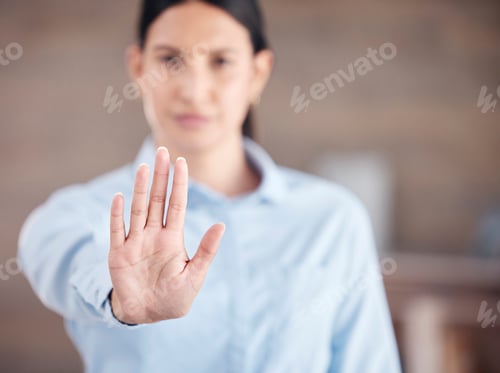 Preview: Closeup of of the hand of a mixed race business man gesturing stop while standing in her office. St