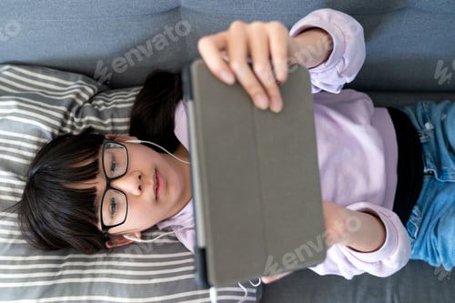 Preview: Teen Relaxing on Couch Using Tablet Device