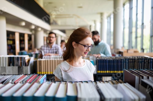 Preview: Happy group of students studying and working together in a college library