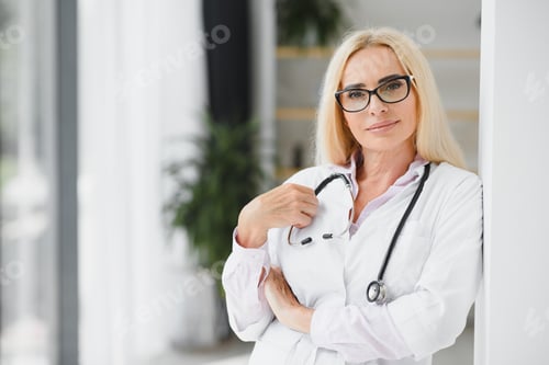Preview: Female doctor wearing lab coat and stethoscope and holding clipboard in her hands
