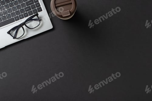 Preview: Workspace featuring a laptop, glasses, and coffee cup arranged on a dark surface providing