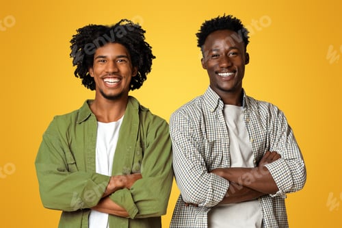 Preview: Two Cheerful Black Male Friends Posing With Folded Arms Over Beige Background