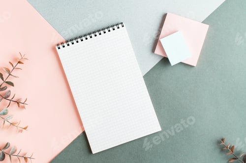 Preview: Blank notepad, writing paper and eucalyptus branches on a colored background. Top view.