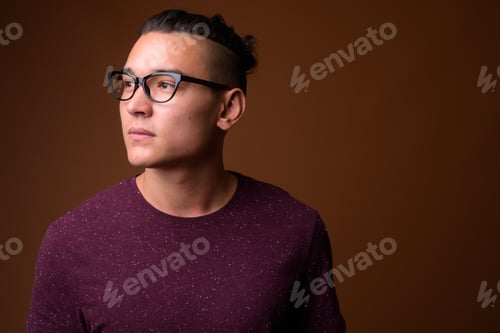 Preview: Young handsome multi-ethnic man against brown background