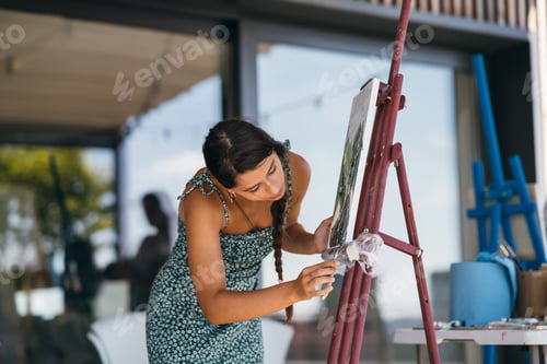 Preview: Woman Painting on Canvas near Window Indoors