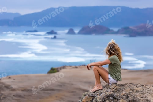 Preview: Indonesia, Lombok, woman sitting at the coast looking at view
