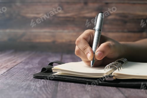 Preview: women hand writing with pen on notepad on table