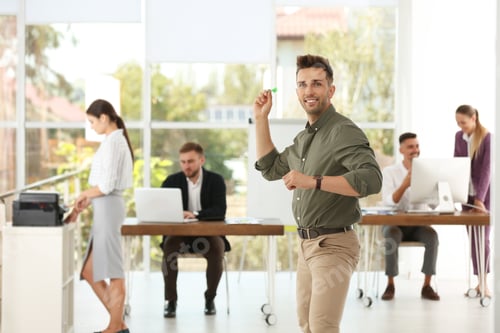 Preview: Happy young businessman with dart and his colleagues in office
