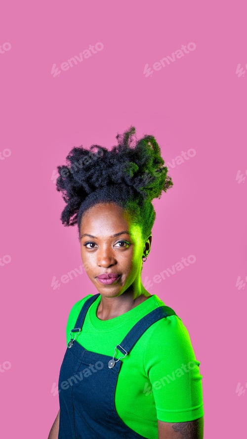 Preview: Studio portrait young black woman looking camera positive and contemplative