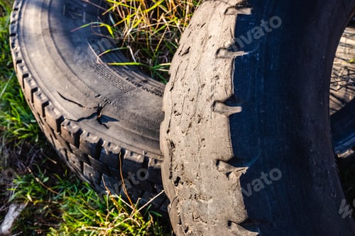Preview: Old wheels of unrecycled cars thrown in a natural field pollute the earth.