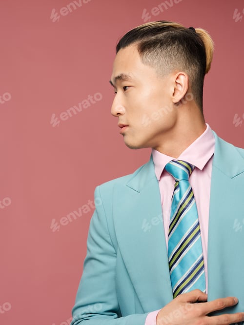 Preview: Man of asian appearance in suit straightens tie self confidence