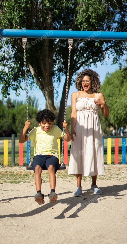 Preview: Latin mother and son enjoying a sunny day on the swings of a playground laughing