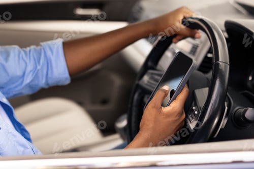 Preview: Happy black man using showing smartphone driving car