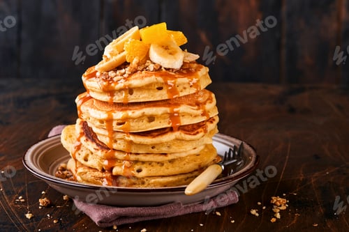 Preview: Pancakes. Homemade fluffy pancake with banana, walnut and caramel for breakfast on dark wooden backg