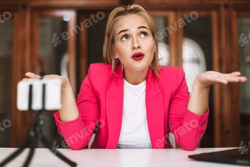 Thoughtful girl in pink jacket amazedly looking aside recording