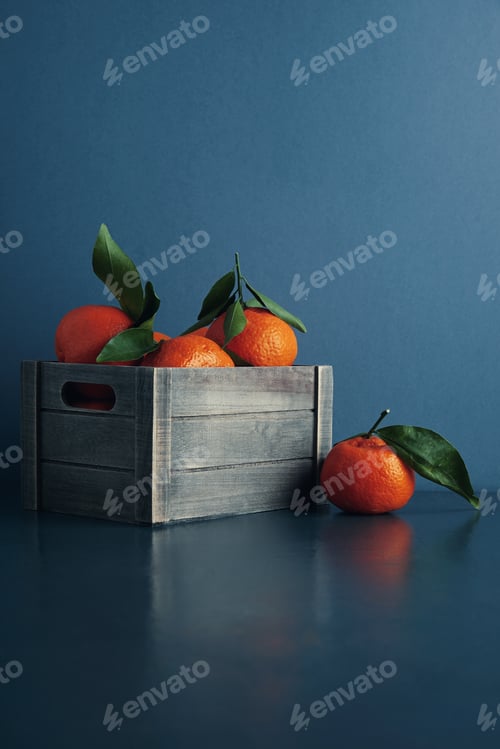 Preview: fresh tangerines in box with leaves isolated
