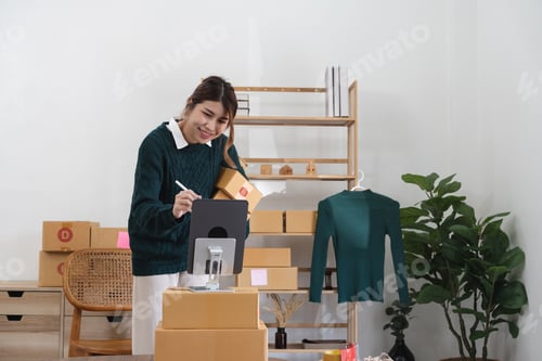 Preview: Asian woman freelancer sme business online shopping working with parcel box at home - SME business