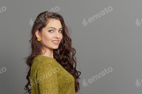 Preview: close-up portrait of beautiful sensual female with long curly hair against gray background