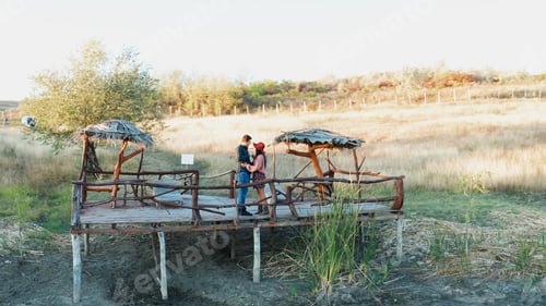 Preview: Beautiful couple clinking glasses with wine on a pontoon