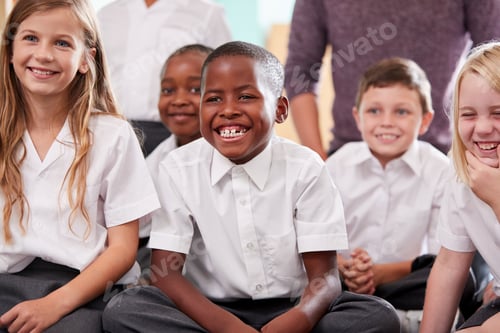 Preview: Group Of Elementary School Pupils Wearing Uniform Sitting On Floor Listening To Teacher