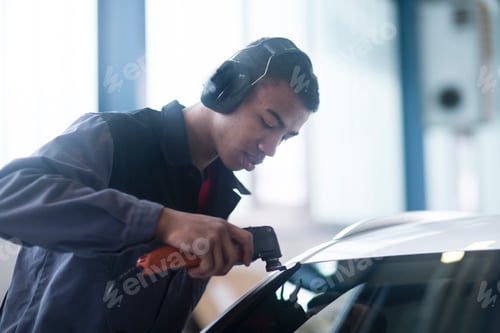 Preview: Auto technician carefully tinting a car window